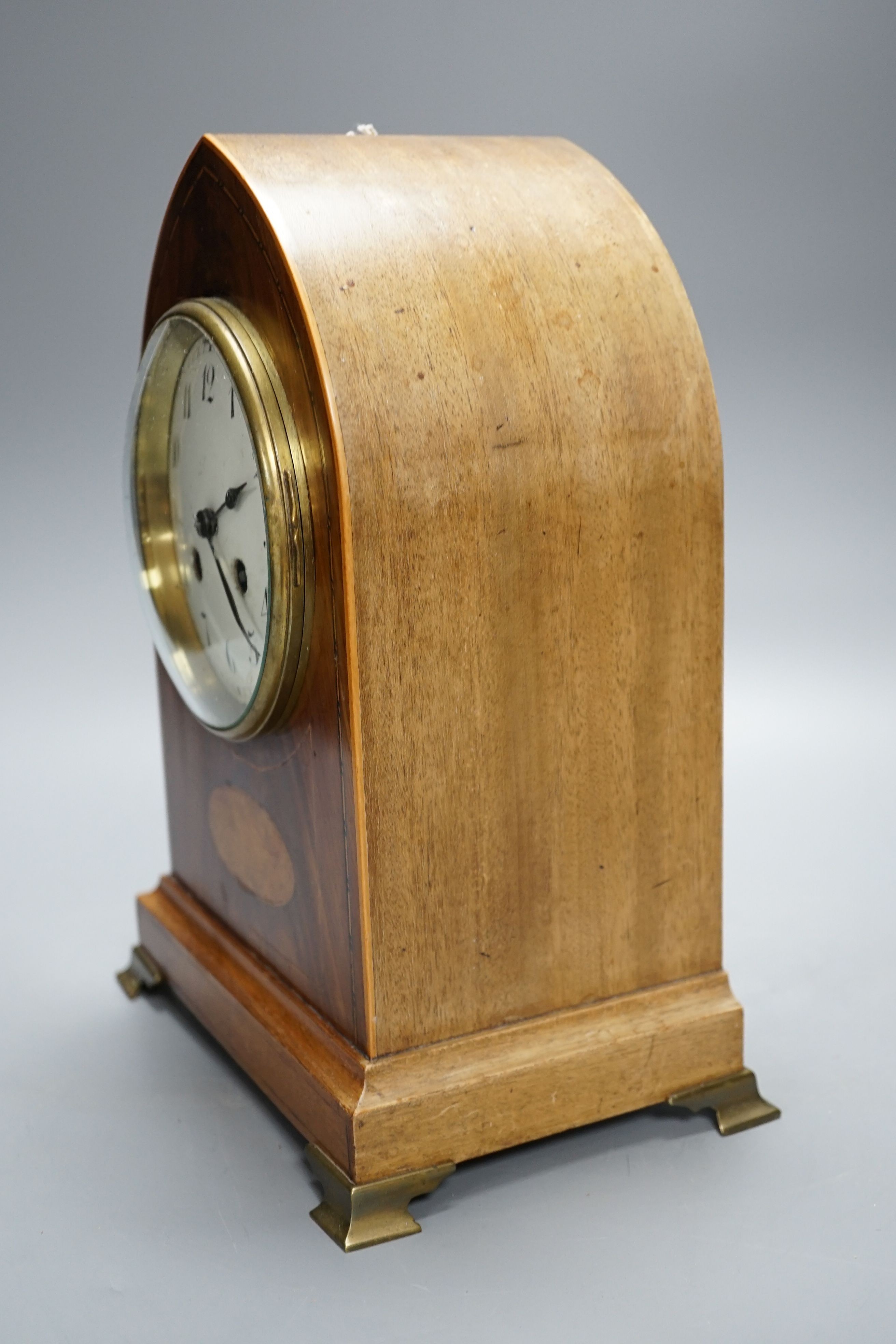 An Edwardian mahogany mantel clock, lancet top case, with white enamelled dial. Key and pendulum. 29cm